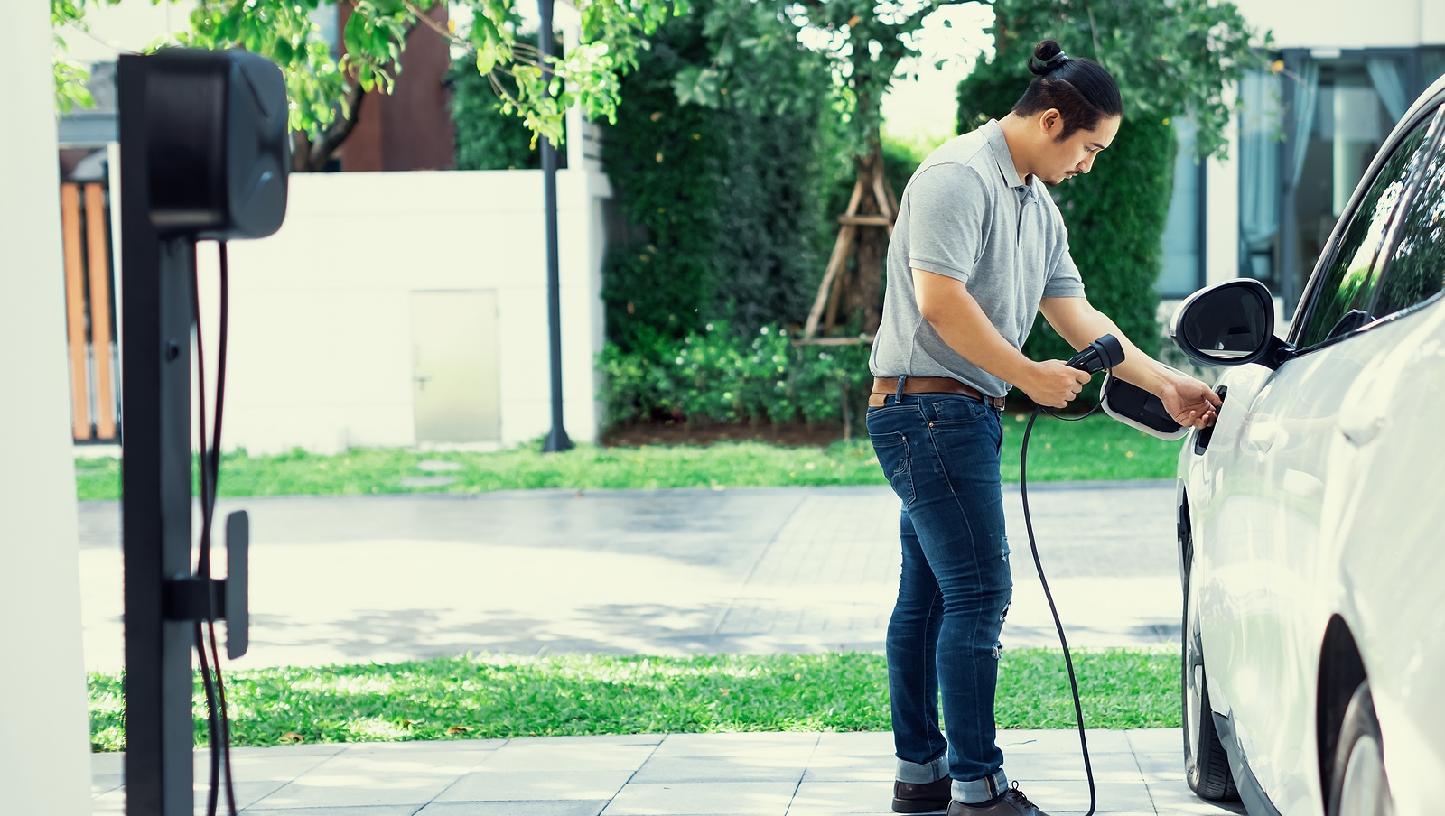 electrical installation course - Man-Installing-Cable-Plug-To-His-Electric-Car-With-Home-Charging-Station-In-The-Backyard